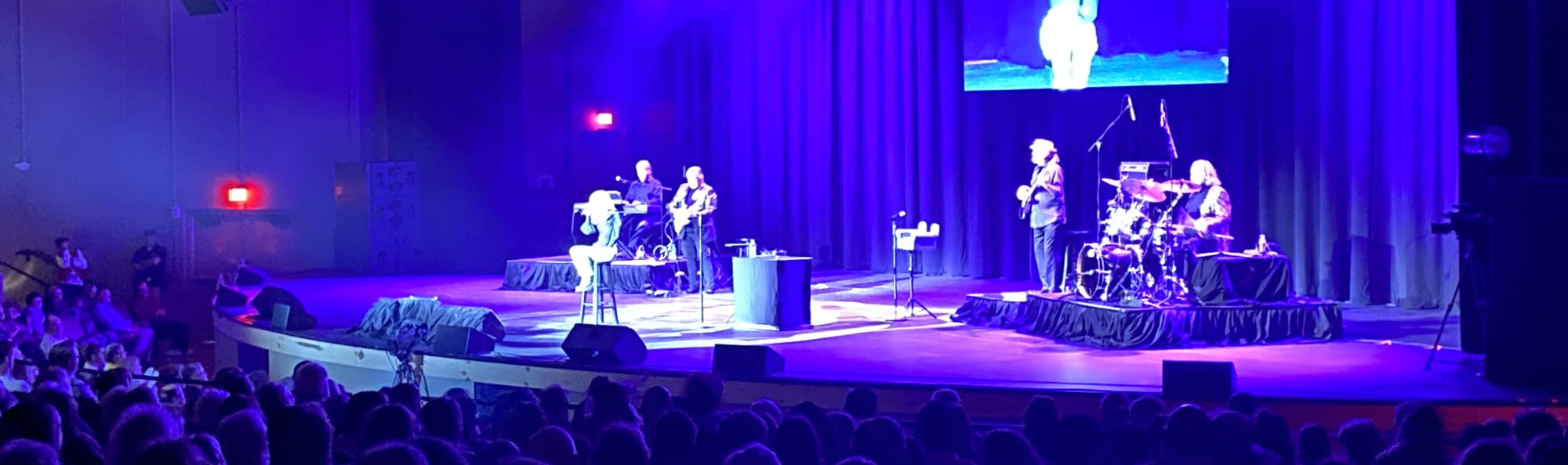 signer on stage in chair washed out by the lights Stockton